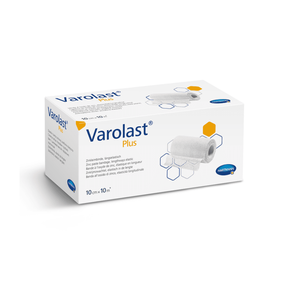 Billedet viser en rektangulær hvid æske med Hartmann Varolast® Plus zink-limbandage. Emballagen viser et billede af en oprullet bandage og sekskantede motiver. Ideel til behandling af ødemer og flebitis; de mål, der er angivet på æsken, er 10 cm x 10 m. Nederst til højre ses logoet for Paul Hartmann AG.
