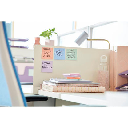 Et moderne kontorbord med notesbøger, en vandflaske, en 3M Deutschland GmbH Post-it® Super Sticky Notes (76 x 127 mm, 90 ark, 100% PEFC) på en skillevæg, en lampe og mapper i baggrunden. Nogle noter viser påmindelser og opgaver.