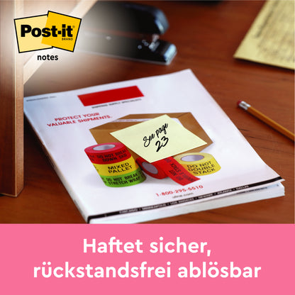 Ein gelber 3M Post-it® Zettel (38 mm x 51 mm, Gelb) mit der Aufschrift "Siehe Seite 23" ist an Papieren auf einem Schreibtisch befestigt. Oben links ist das Post-it-Logo zu sehen, unten steht eine deutsche Information über Haftnotizen, 100 Blatt/Block.