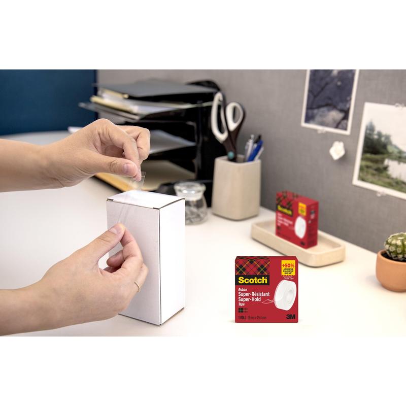 En person forsegler en hvid æske med kontorartikler med Scotch® Super-Hold Secure Tape, 1 rulle, 19 mm x 25,4 m fra 3M Deutschland GmbH. Emballagen til tapen er indsat i nederste højre hjørne.