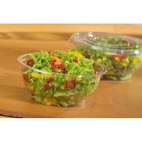 Foran ses en rund, glasklar Starpak 50 salatskål R-PET med blandet salat, cherrytomater og gul peberfrugt, i baggrunden en anden miljøvenlig Starpak salatskål - begge med gennemsigtige plastiklåg.