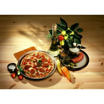 En peberonipizza serveres på en tallerken ved siden af vin, salami, oliven og friske produkter. Fagligt bagt i Starpak 25 Rundformer, Alu rund fra Starpak for optimal varmeledning på et rustikt træbord.