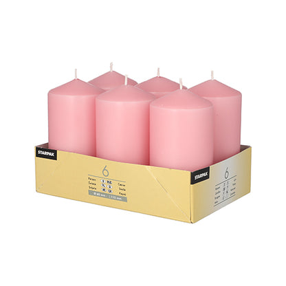 En gul 'STAMPAK'-bakke rummer seks Starpak søjlelys (Ø 60 mm · 115 mm) i pink. Disse store, flade lys har synlige væger og tilbyder lang brændetid.