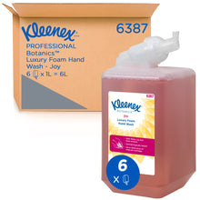 En rød 1-liters kassette Kleenex® Botanics™ Luxury Foam Hand Wash fra Kimberly-Clark GmbH står foran en "6387"-æske, der indeholder seks 1-liters kassetter, med synlig branding og plantebaserede ingredienser.