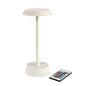 Den NOUR trådløse LED-lampe i sandfarve fra Duni GmbH er en moderne bordlampe med rund sokkel og flad overflade - elegant dekoration til dit hjem, inklusive fjernbetjening med flere farverige knapper.