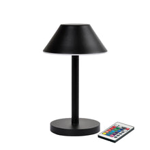 LED-lampen Zelda Midi fra Duni GmbH i moderne grafitdesign med rund sokkel og konisk skærm står ved siden af en fjernbetjening med farverige knapper - den ideelle, energieffektive belysningsløsning.