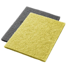 To gule Twister Pads til stenbundsrenovering fra Diversey Deutschland GmbH & Co. OHG (2 stk.) er afbildet fladt liggende og let overlappende foran en hvid baggrund.