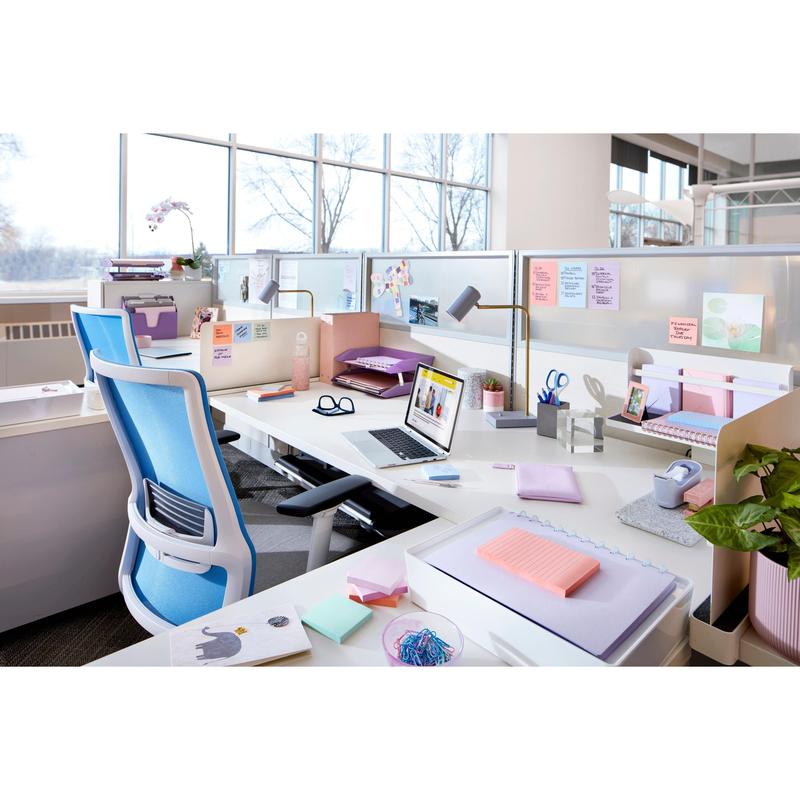 En moderne kontorarbejdsplads med hvide skriveborde, blå stole, bærbare computere, kontorartikler, potteplanter og naturligt lys viser Post-it® Super Sticky Notes (76 mm x 127 mm, 90 ark/blok, 100% PEFC) fra 3M Deutschland GmbH.