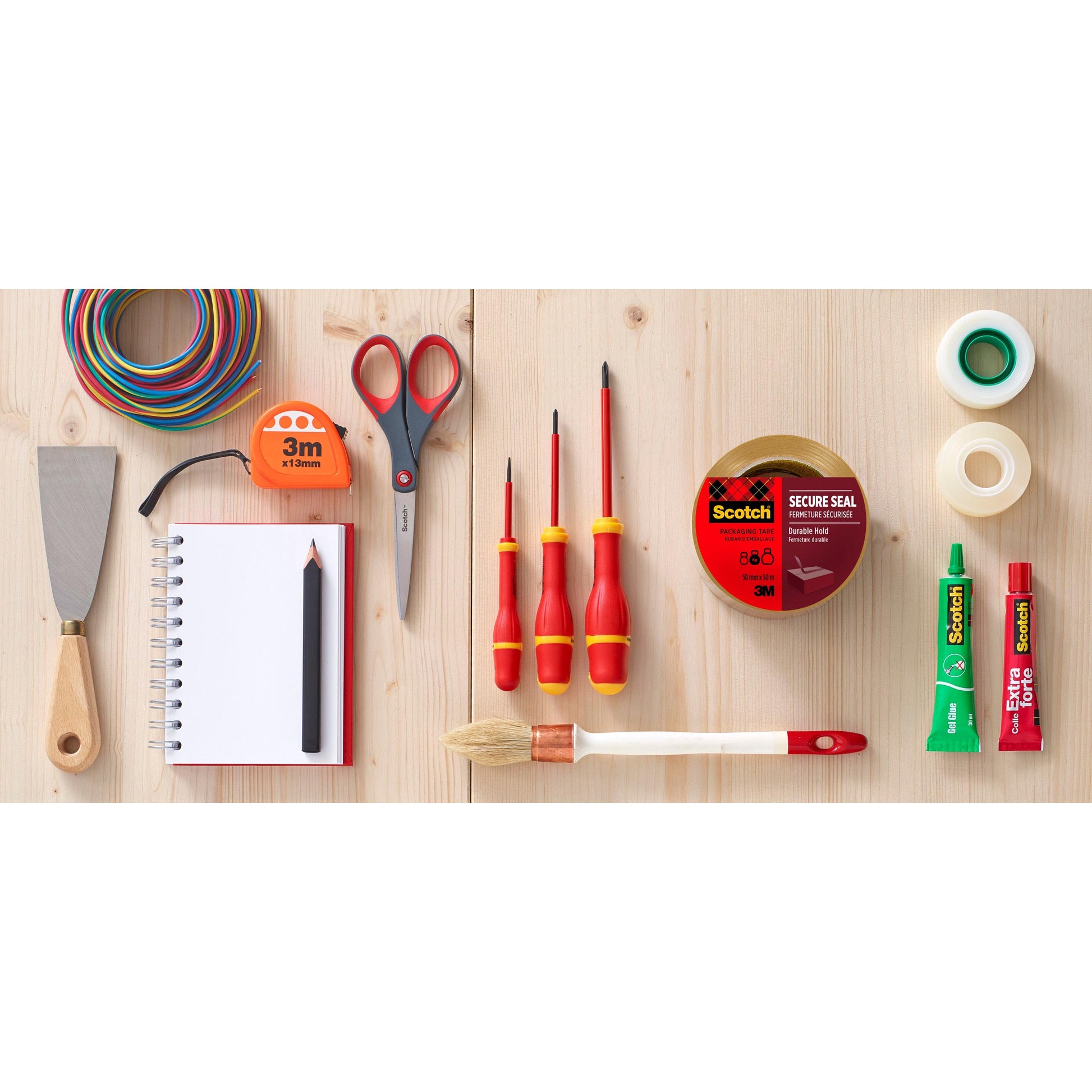 Verschiedene Werkzeuge und Schreibwaren auf einer Holzfläche, mit dem 3M Abroller mit Pistolengriff und Scotch® Verpackungsklebeband (Braun, 50 mm x 66 m, 1 Spender + 2 Rollen/Packung) von 3M Deutschland GmbH für den sicheren Verpackungsabschluss.