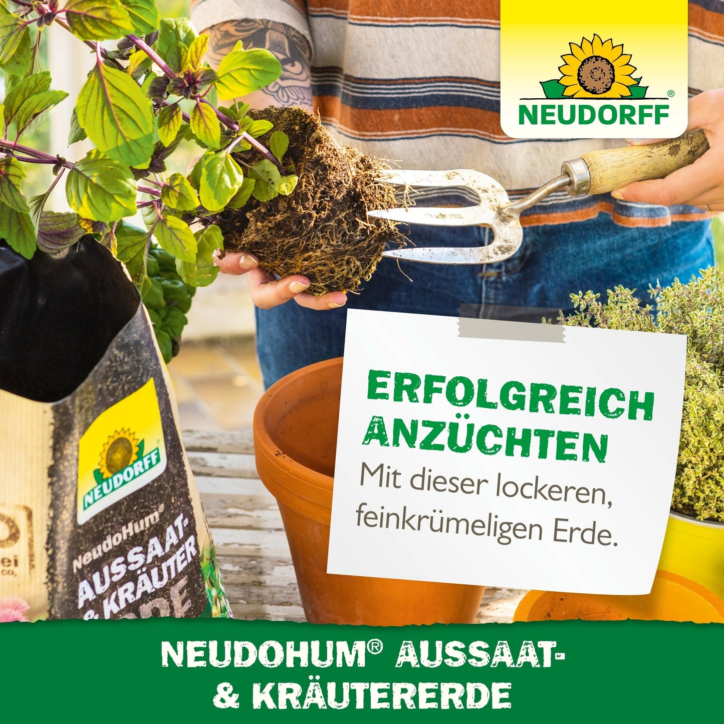 En person bruger en havegaffel til at forberede jorden i en rektangulær plantebeholder. Ved siden af står en pose med NeudoHum Så- & Krydderurtejord fra Neudorff Shop med middelhavskrydderurter, krydderurteplanter, branding og tysk reklametext.