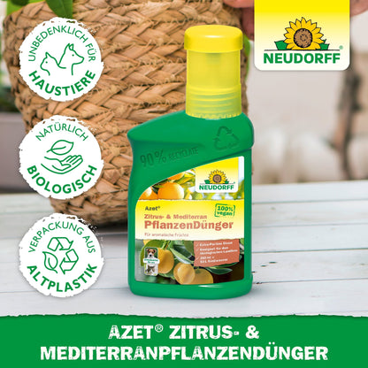 En grøn flaske Neudorff Shop Azet Citrus- & MiddelhavsplanterGødning til middelhavsplanter i krukker står på et bord, med synlig etiket og omgivende symboler, der indikerer sikkerhed for kæledyr, naturlige ingredienser og en genanvendt emballage.