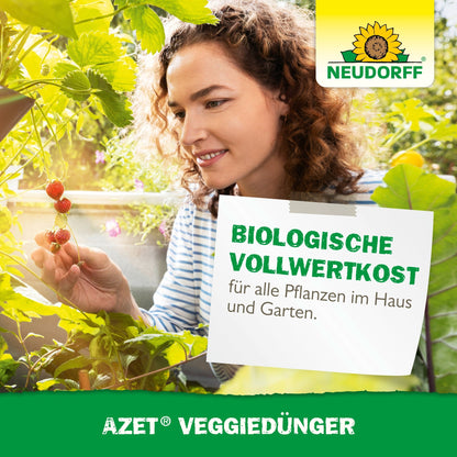 En kvinde i en have inspicerer og plukker små røde bær. Billedet viser Neudorff Shops logo og reklamerer for Azet VeggieGødning, en organisk plantegødning til hus- og haveplanter.