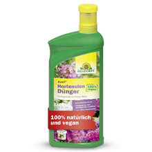 En grøn flaske Neudorff Shop Azet HortensienGødning flydende med en gul hætte. Etiketten viser blomster og de tyske sætninger "100% vegansk" og "100% naturlig og vegansk".