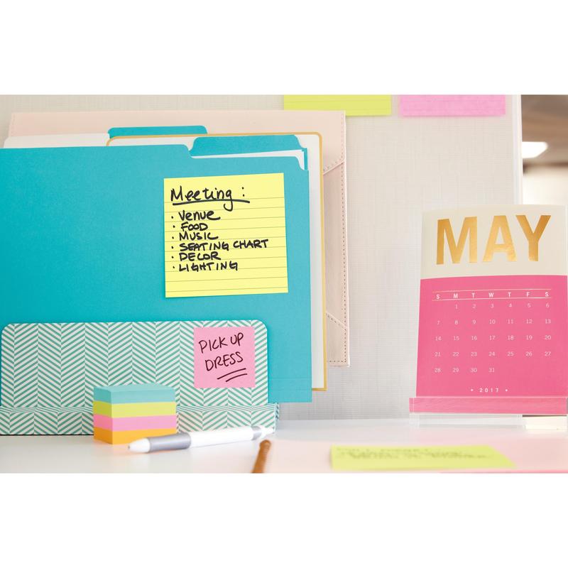 Et arbejdsområde med 3M Deutschland GmbH Post-it® Notes i storformat, Gul (101 mm x 152 mm), ringbind, en rosa-guld bordkalender for maj 2017 samt farverige klistermærker og papirer. En seddel lister "Meeting"-emner op, på en anden står "PICK UP DRESS".