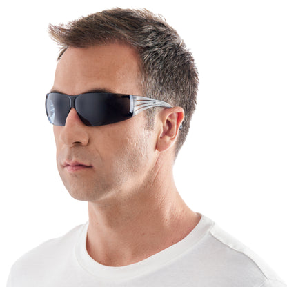 Ein Mann mit kurzen braunen Haaren, in einem weißen T-Shirt, trägt eine 3M™ SecureFit™ Schutzbrille 200 von 3M Deutschland GmbH, leicht nach links gewandt vor einem schlichten weißen Hintergrund.
