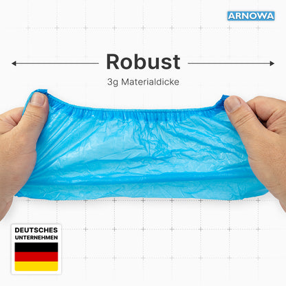 To hænder strækker et blåt ARNOMED CPE skobetræk op i luften og understreger dermed den "Robuste", "3g materialetykkelse" kvalitet. Teksten fremhæver ARNOWA GmbH og det tyske flag og viser, at disse vandtætte engangsskobetræk er lavet til holdbarhed.