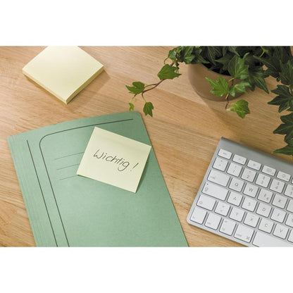 En grøn mappe med en Post-it® genbrugsseddel (38mm x 51mm, 100 ark, 100% PEFC af 3M Deutschland GmbH) med påskriften "Vigtigt!" ligger på et træskrivebord ved siden af et tastatur, flere klistermærker og en potteplante.