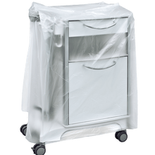 Et hvidt medicinsk natbord på hjul er delvist dækket med en transparent DEISS 59867 natbordshætte (600+500x1000x0,01 mm) fra EMIL DEISS KG, som skjuler skufferne og grebene. Baggrunden er enkel og neutral.