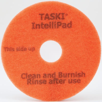 TASKI Intellipad Kombineret rengørings- og poleringspad til vedligeholdelsesrengøring fra Diversey Deutschland GmbH & Co. OHG er en orange, cirkulær pad med et hul i midten og teksten "TASKI IntelliPad", "Denne side opad" og "Rengør og polér, Skyl efter brug" i grå skrift.