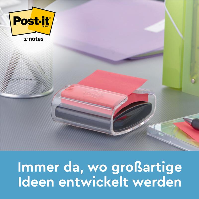 En Post-it® Z-Notes dispenser i bjørneform, hvid, med blå Super Sticky Z-Notes (76 x 76 mm) fra 3M står på et skrivebord ved siden af penne og mapper. Tekst nedenfor: "Altid der, hvor fantastiske idéer udvikles.