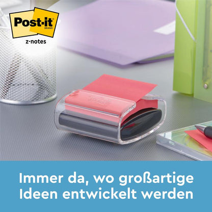 En Post-it® Z-Notes dispenser i bjørneform, hvid, med blå Super Sticky Z-Notes (76 x 76 mm) fra 3M står på et skrivebord ved siden af penne og mapper. Tekst nedenfor: "Altid der, hvor fantastiske idéer udvikles.