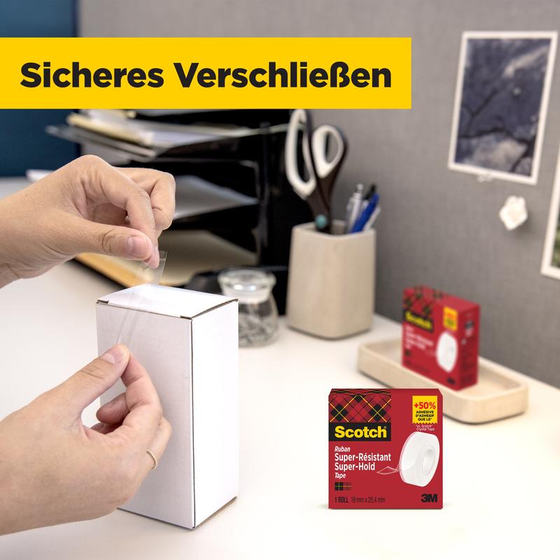 En person forsegler en hvid pakke på bordet med Scotch® Super-Hold Secure Tape, 1 rulle, 19 mm x 25,4 m fra 3M Deutschland GmbH. I baggrunden ses kontorartikler og emballagen til det gennemsigtige tape.