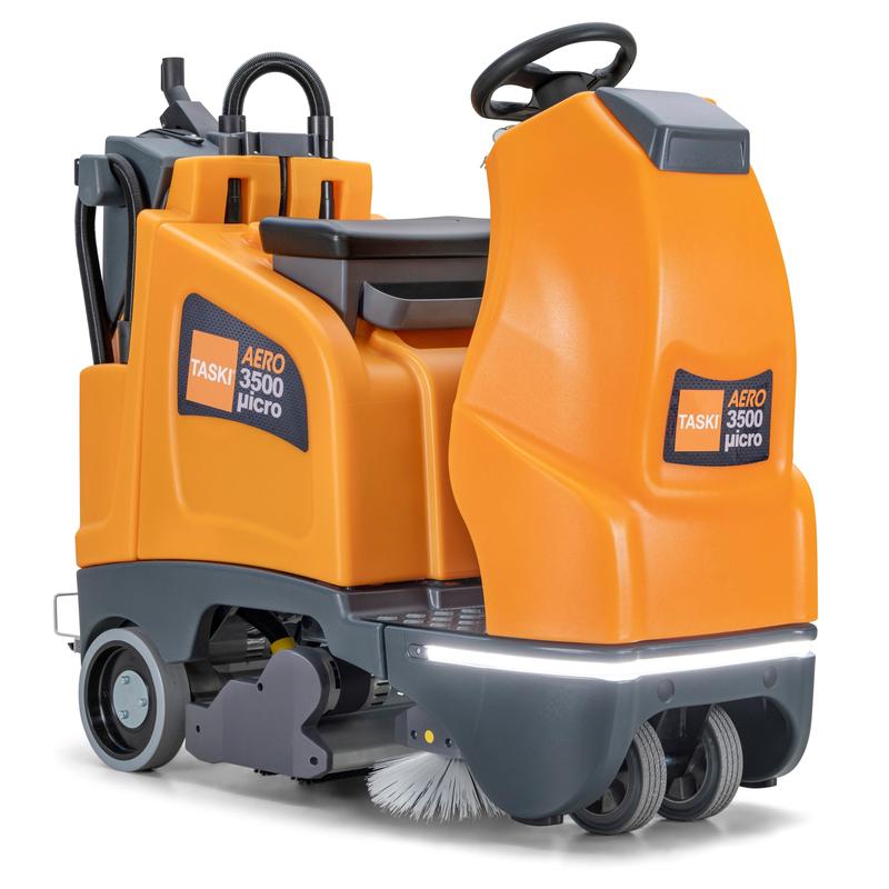 Den TASKI AERO 3500µicro B BMS Li 150 fra Diversey er en kompakt orange-grå ride-on støvsuger baseret på swingo 2100 med sæde, rat, lithium-ion-batterier, integreret oplader og synlige frontbørster og hjul.