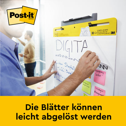 En person skriver på et 3M Deutschland GmbH Post-it® Super Sticky selvklæbende mødechart/flipchart til vægmontering 566 (58,4 x 50,8 cm, hvid), der er fastgjort med Command™-strimler på et whiteboard; farverige klisternoter er påsat.