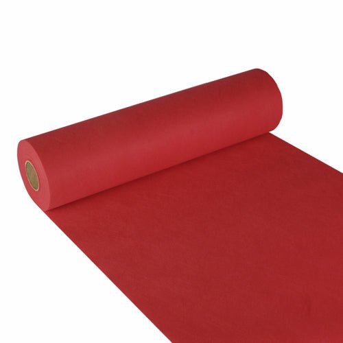 En rulle Starpak bordløber, stoflignende fleece „Soft Selection“ (24 m x 40 cm), er delvist rullet ud på en hvid overflade, rullen ligger til venstre, og den røde løber strækker sig til nederste højre hjørne.