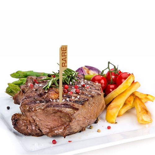 En grillet, blodig bøf, markeret med PAPSTAR 250 Steak-markør (9 cm) fra PAPSTAR GmbH, serveret med pommes frites, asparges, cherrytomater på stilk, røde løg og garneret med rosmarin og peberkorn - helt i restaurantstil.