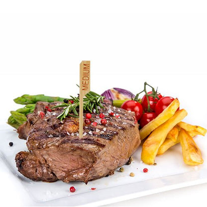 En grillet bøf med betegnelsen "medium" og PAPSTAR 250 Steak-markør 9 cm fra PAPSTAR GmbH serveres på en hvid tallerken med pommes frites, asparges, cherrytomater, røde løg og krydderurter - perfekt til det professionelle restaurantkøkken.