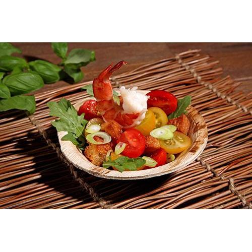 Nyd rejer, cherrytomater, croutoner, rucola og forårsløg i en PAPSTAR GmbH Skål af palmeblad »pure«, rund (13 cm), miljøvenlig – det perfekte bæredygtige engangsservice til miljøbevidste arrangementer.