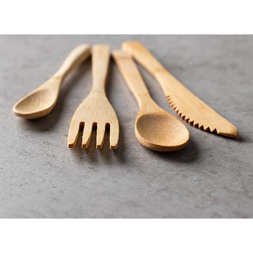 Ti miljøvenlige PAPSTAR bambusgafler "pure" (16,5 cm) fra PAPSTAR GmbH er lagt ved siden af hinanden på en grå overflade.