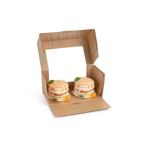 En PAPSTAR 25 kageæsker med firkantet låg med PLA-vindue fra PAPSTAR GmbH er åbnet og viser to små runde kager med hvid glasur, orange stænk og frugtstykker i.