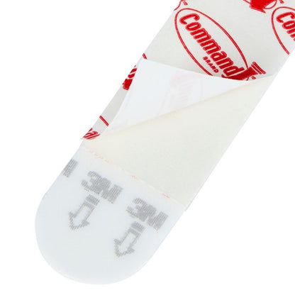 Et nærbillede af et Multipack Command™ Strips, 17200 fra 3M Deutschland GmbH med delvist fjernet beskyttelsesfolie, der viser klæbeoverfladen og den trykte vejledning til ophængning af billeder - de perfekte klæbestrips uden boring.