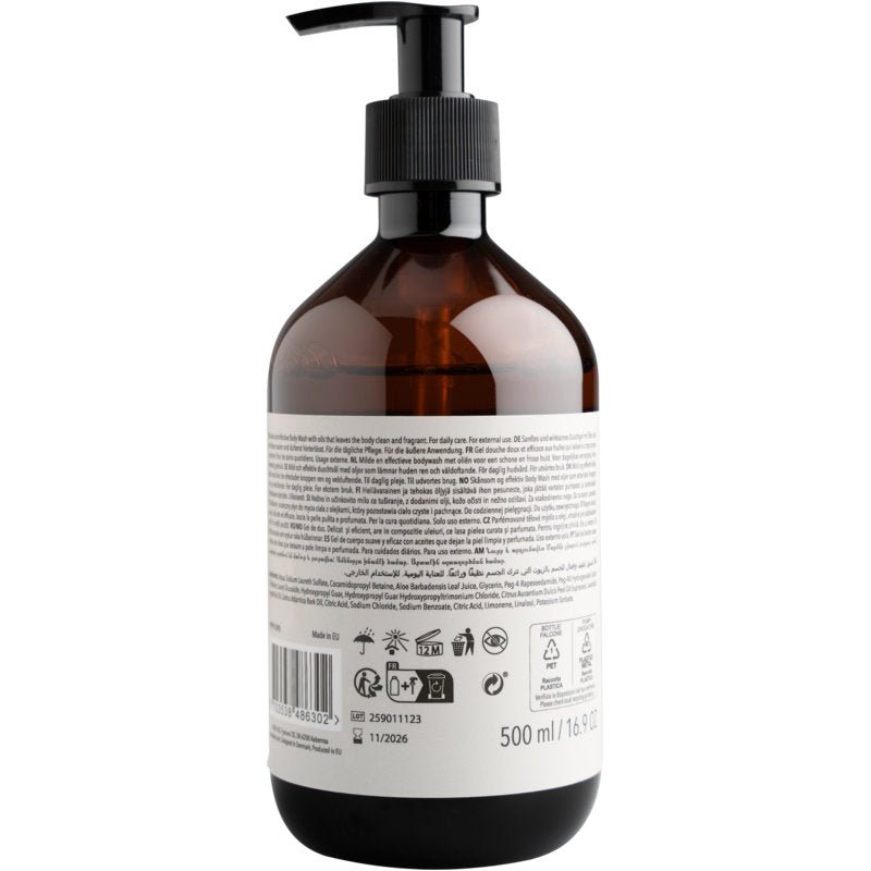 En brun plastikflaske med en sort pumpe og en stor hvid etiket viser stregkoden, genbrugssymboler og 500 ml volumen for ENA Living Body Wash fra Abena Re-Seller GmbH, solgt som kasse (8 pakker).