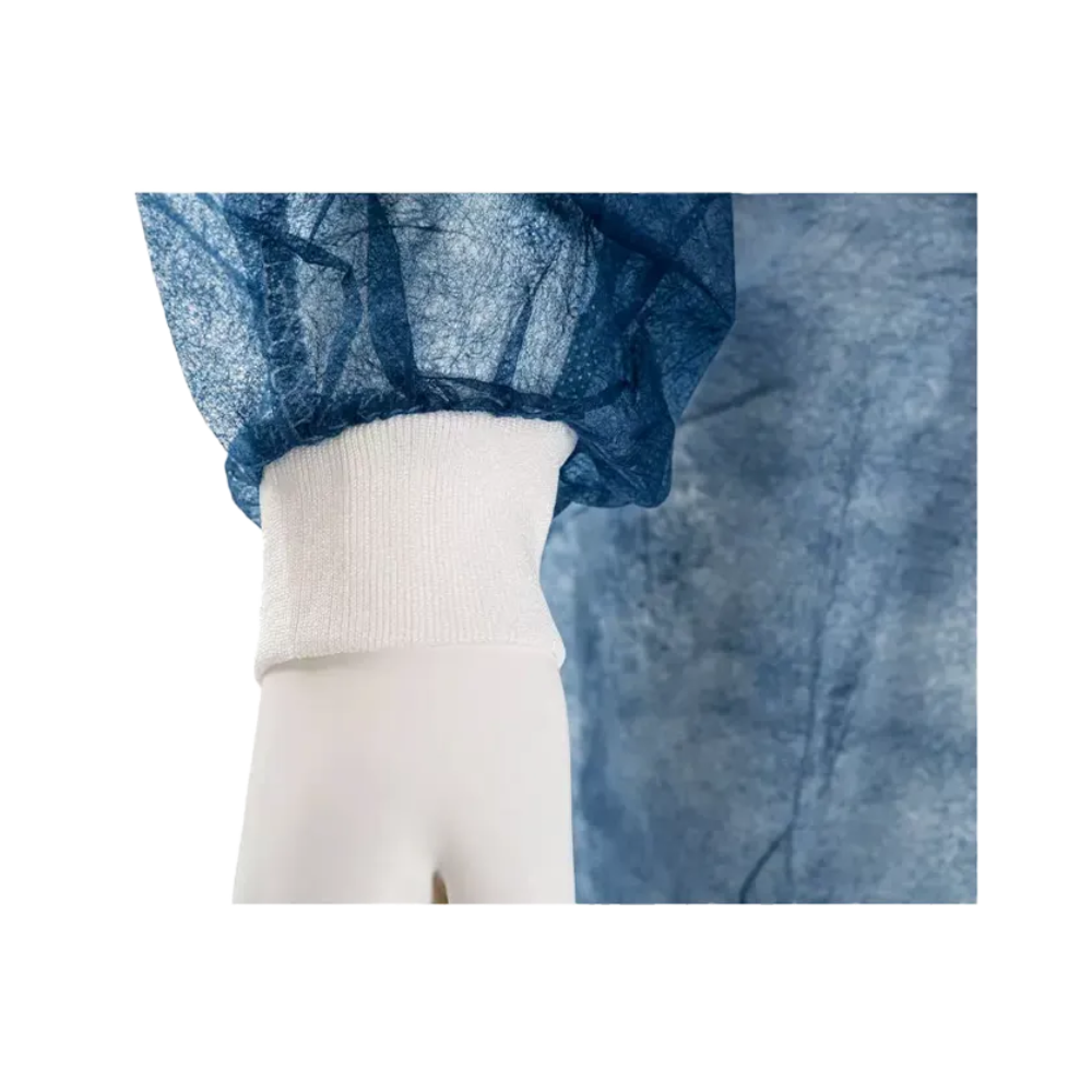 Nærbillede af en mannequins hånd, der bærer en blå, halvtransparent beklædningsgenstand med en hvid elastisk manchet. Denne AMPri MED-COMFORT PP engangsbesøgsfrakke til at binde med trikotmanchetter, fremstillet af AMPri Handelsgesellschaft mbH, er lavet af krøllet polypropylen-materiale og giver en behagelig pasform omkring håndleddet.