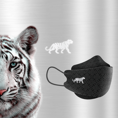 Das Bild zeigt eine Nahaufnahme eines weißen Tigers mit markanten Streifen. Neben dem Tiger befindet sich eine Altruan Designer-Gesichtsmaske, die dem FFP2-Standard entspricht und ein passendes Tigerdesign aufweist. Der Hintergrund ist ein dezent strukturiertes metallisches Silber.