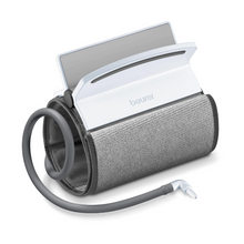 En oprullet Beurer universalmanchet til blodtryksmåler BM 51 manchet med tilsluttet hvid digitalmonitor. Fra universalmanchetten går en fleksibel slange, der ender i et tilslutningsstykke, som bruges til tilslutning til en måleenhed. Den let skrånende monitorskærm er delvist synlig. Passer til overarmsomkredse fra 22 - 42 cm.