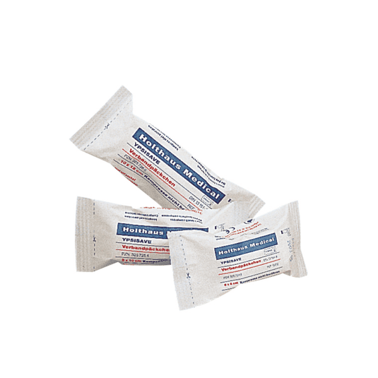 Der er udstillet tre pakker med Holthaus Medical YPSISAVE-bandagepakker, sterile, hver med blå og rød påskrift. Teksten på emballagen er formodentlig på tysk og indeholder produktoplysninger. Hver pakke er individuelt indpakket og forseglet, hvilket tyder på, at der er tale om sterile bandagepakker fra Holthaus Medical GmbH & Co. KG.