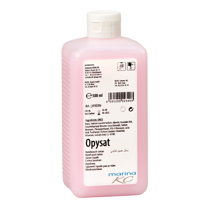 En lyserød 500 ml flaske Kiehl Opysat håndvasklotion fra Johannes Kiehl KG, en pH-neutral håndsæbe, har en hvid etiket med produktinformation, ingredienser, stregkode, symboler og "marina KC" i bunden til skånsom håndvask.