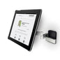En Novocal-tabletholder version 1 (til tablets 7-12 tommer, svingbar op til 180°) er monteret på en sølvfarvet vægbeslag med svingarm; på tabletten ses en hjemmeside med "novocal" som overskrift.