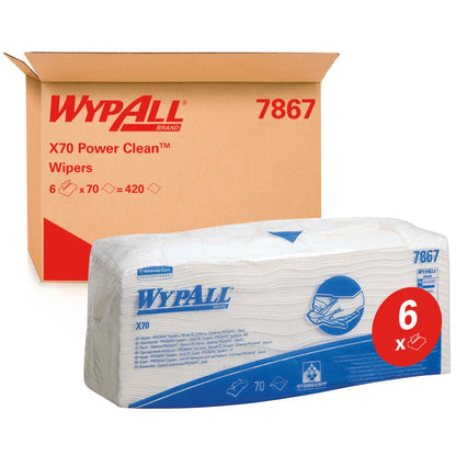 En pakke WypAll® X70 viskestykker - foldet / Hvid (6 poser x 70 klude) fra Kimberly-Clark GmbH er afbildet foran en kasse med teksten "WypAll 7867". Det røde "6x"-etiket fremhæver rengøringskludene i industrikvalitet med blå branding.