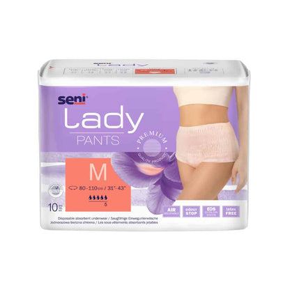 En pakke med absorberende undertøj Seni Lady Pants i størrelse Medium, som er udviklet til inkontinens, viser et billede af produktet på en kvindelig model. Emballagen fremhæver egenskaber som åndbarhed og sikkerhed. Produktet er fra TZMO Deutschland GmbH.