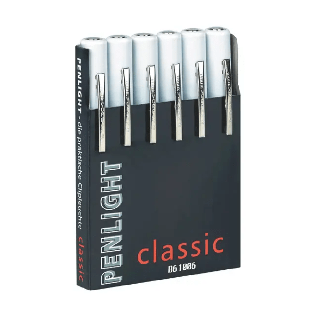 En sort boks med påskriften „Penlight Classic Six Pack Dispenser, trykt“ fra Servoprax GmbH indeholder seks hvide, penformede lommelygter, som ofte bruges ved medicinske undersøgelser. Hver penlygte har en sølvfarvet clip for nem adgang under diagnosen.