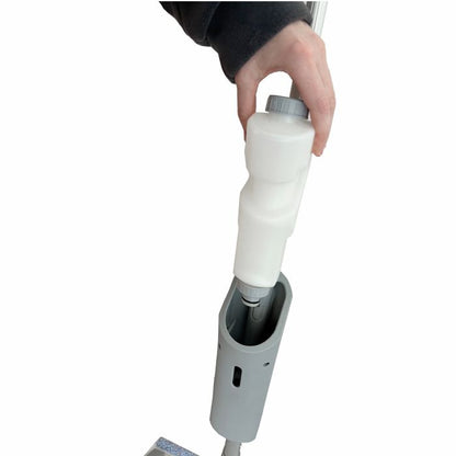 En person indsætter en hvid rengøringsløsningsflaske i håndtaget på Arcora Ultra Mobile Spray Mop System fra Arcora International GmbH på hvid baggrund.
