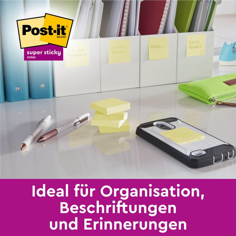 Et skrivebord med penne, en smartphone, stablede Post-it® Super Sticky Notes (76 mm x 127 mm, 90 ark/blok, 100% PEFC) fra 3M Deutschland GmbH og mapper med noter. Dansk tekst: "Ideel til organisering, mærkning og påmindelser.