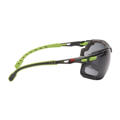 En 3M™ Solus™ beskyttelsesbrille 1000 fra 3M Deutschland GmbH i grøn/sort med Scotchgard™ antidug-belægning, aftagelig skumforsegling og grå glas i sidevisning på hvid baggrund.