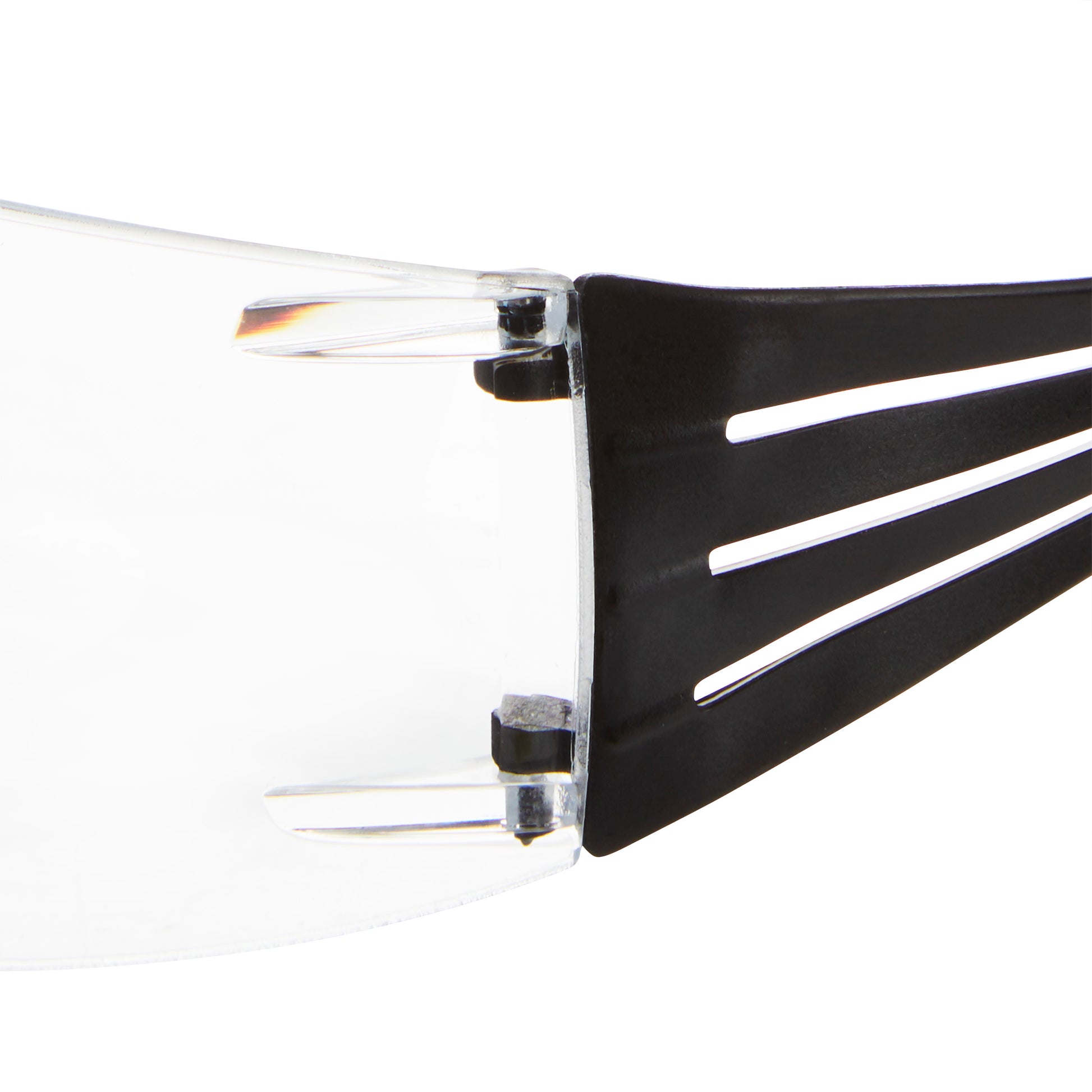 Nahaufnahme der 3M™ SecureFit™ Lese-Schutzbrille der 3M Deutschland GmbH. Sie zeigt die klare Scheibe und den schwarzen Bügel mit drei parallelen Schlitzen sowie das sichtbare Scharnier, das den Bügel mit der Scheibe verbindet.