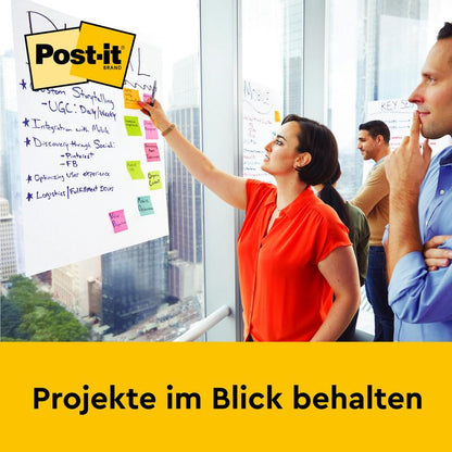 En kvinde skriver noter på et Post-it® Super Sticky selvklæbende mødeplanchart/flipchart (63,5 x 76,2 cm, 30 ark, 2 blokke) fra 3M Deutschland GmbH ved vinduet, mens to mænd ser på. "Hold øje med projekter" står derunder.